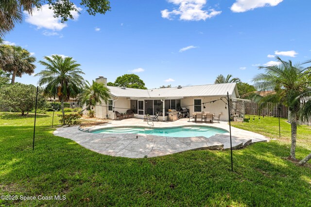 740 Hunan St NE, Palm Bay, FL 32907 - back of house with a sunroom, a patio, an outdoor pool, and a chimney