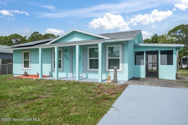 926 Caligula Ave SE, Palm Bay, FL 32909 - view of front of home with solar panels, covered porch, a sunroom, stucco siding, and roof with shingles