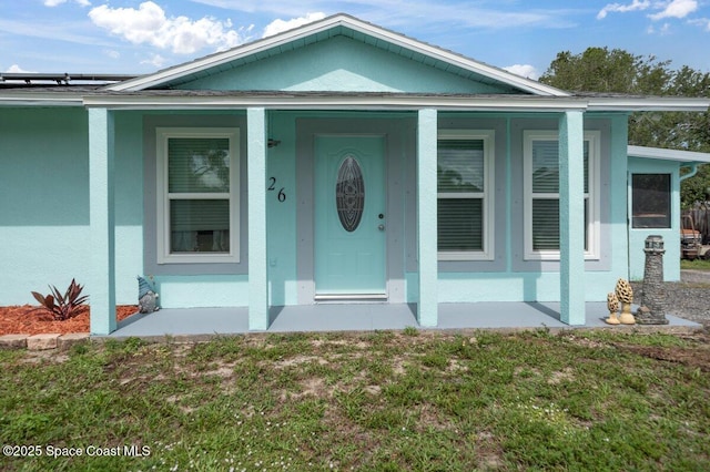 926 Caligula Ave SE, Palm Bay, FL 32909 - entrance to property featuring stucco siding, a porch, and a yard