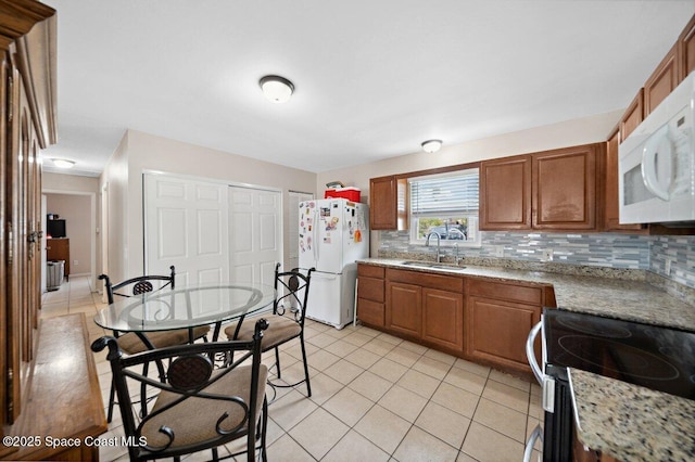 926 Caligula Ave SE, Palm Bay, FL 32909 - kitchen featuring white appliances, a sink, decorative backsplash, brown cabinetry, and light tile patterned floors