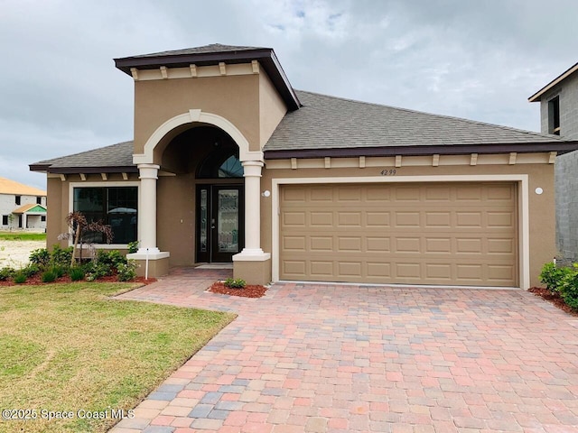 4299 Alligator Flag Cir, West Melbourne, FL 32904 - mediterranean / spanish-style house featuring roof with shingles, decorative driveway, stucco siding, and an attached garage