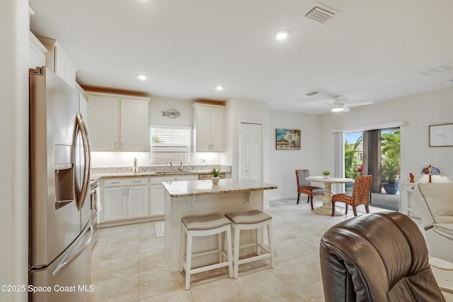 4299 Alligator Flag Cir, West Melbourne, FL 32904 - kitchen featuring stainless steel refrigerator with ice dispenser, plenty of natural light, a center island, light stone countertops, and recessed lighting