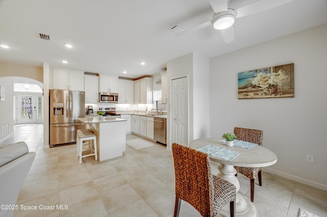 4299 Alligator Flag Cir, West Melbourne, FL 32904 - dining area featuring arched walkways, ceiling fan, recessed lighting, light tile patterned flooring, and baseboards