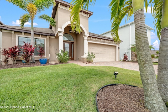 4299 Alligator Flag Cir, West Melbourne, FL 32904 - mediterranean / spanish-style house with stucco siding, driveway, an attached garage, a front lawn, and roof with shingles