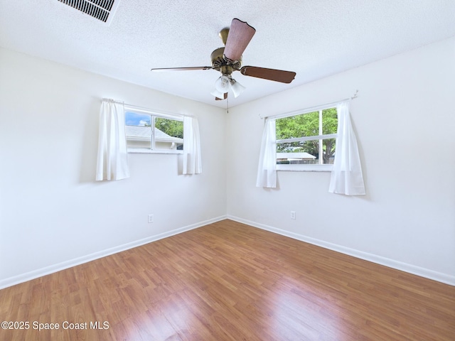 2115 Otterbein Ave, Cocoa, FL 32926 - empty room with plenty of natural light, wood finished floors, baseboards, and a textured ceiling