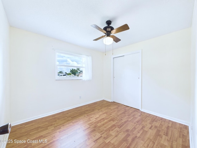 2115 Otterbein Ave, Cocoa, FL 32926 - unfurnished bedroom featuring light wood-type flooring, a closet, baseboards, and a ceiling fan