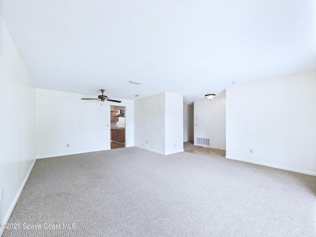 2115 Otterbein Ave, Cocoa, FL 32926 - unfurnished living room featuring carpet, baseboards, and a ceiling fan