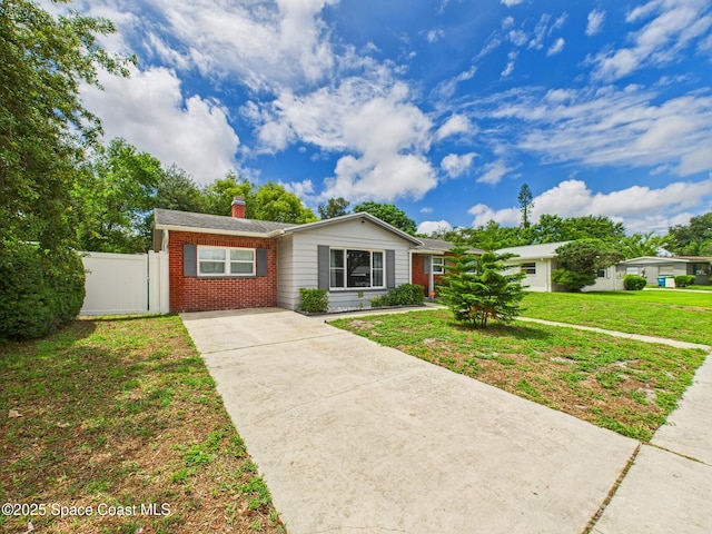 2115 Otterbein Ave, Cocoa, FL 32926 - ranch-style home featuring brick siding, driveway, and a chimney
