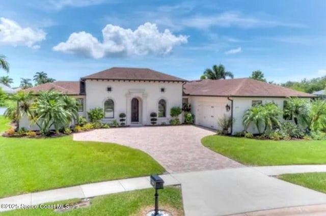 3180 Savannahs Trl, Merritt Island, FL 32953 - mediterranean / spanish-style home with decorative driveway, a front lawn, a garage, and stucco siding