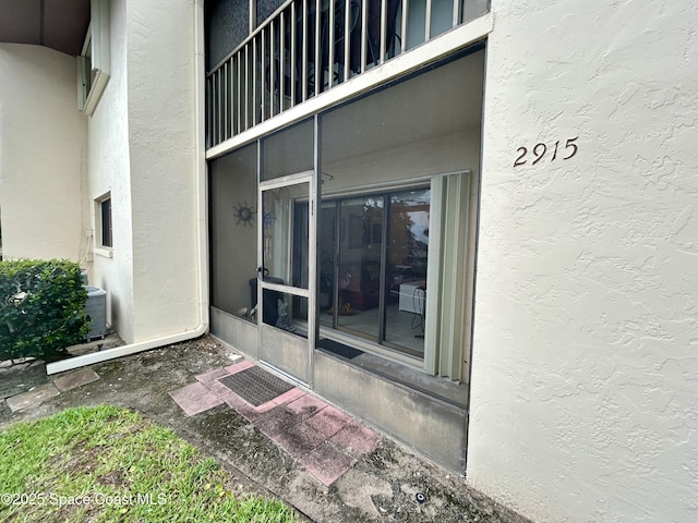 2915 Kirkland Rd NE, Palm Bay, FL 32905 - doorway to property with stucco siding and a balcony