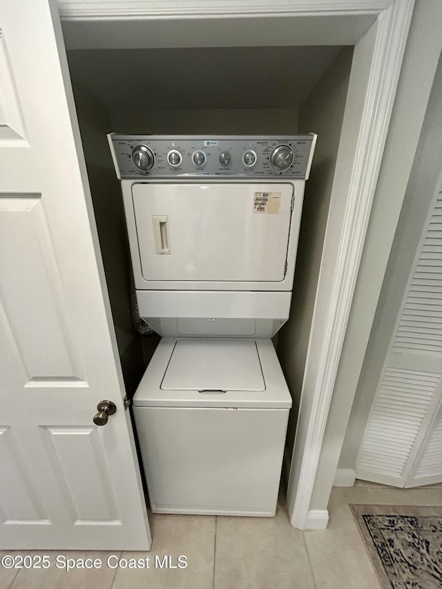 2915 Kirkland Rd NE, Palm Bay, FL 32905 - washroom with stacked washer / dryer, light tile patterned floors, and baseboards