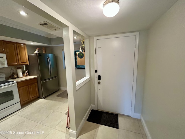 2915 Kirkland Rd NE, Palm Bay, FL 32905 - kitchen featuring white appliances, brown cabinets, light tile patterned floors, baseboards, and recessed lighting