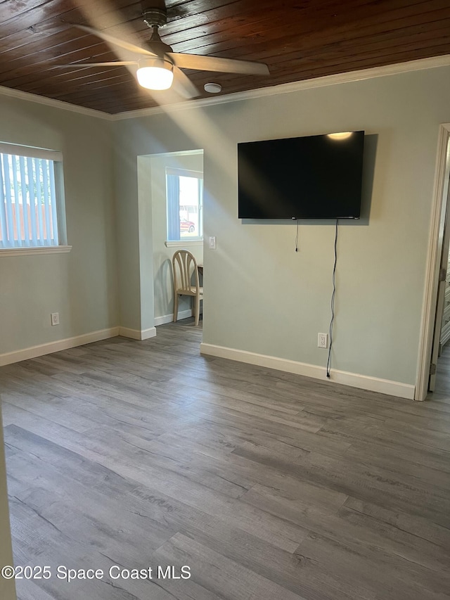 6409 Ridgewood Ave Unit 6409, Cocoa Beach, FL 32931 - unfurnished living room featuring ornamental molding, wood ceiling, healthy amount of natural light, ceiling fan, and baseboards