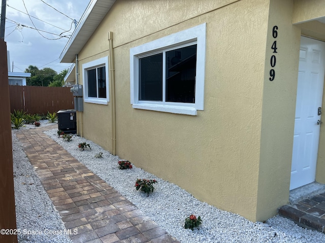 6409 Ridgewood Ave Unit 6409, Cocoa Beach, FL 32931 - view of side of property featuring stucco siding and central AC unit