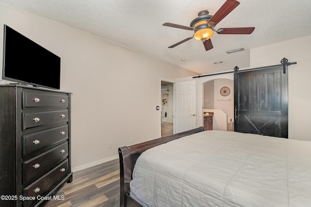 6313 Leonard Ave, Cocoa, FL 32927 - bedroom featuring wood finished floors, a barn door, a textured ceiling, and ceiling fan