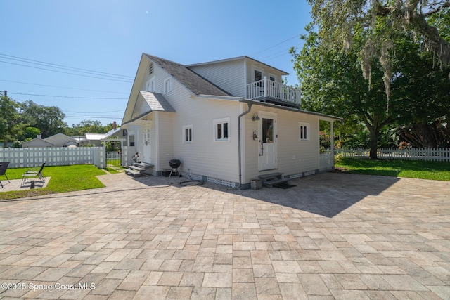 1248 Highland Ave, Melbourne, FL 32935 - rear view of property with entry steps, a balcony, a patio, and a shingled roof