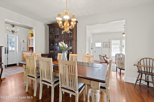 1248 Highland Ave, Melbourne, FL 32935 - dining space featuring a chandelier, wood-type flooring, and baseboards