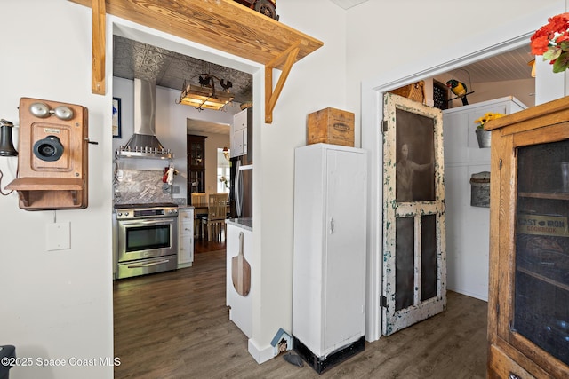 1248 Highland Ave, Melbourne, FL 32935 - kitchen featuring stainless steel range oven, wall chimney range hood, dark wood finished floors, decorative backsplash, and baseboards