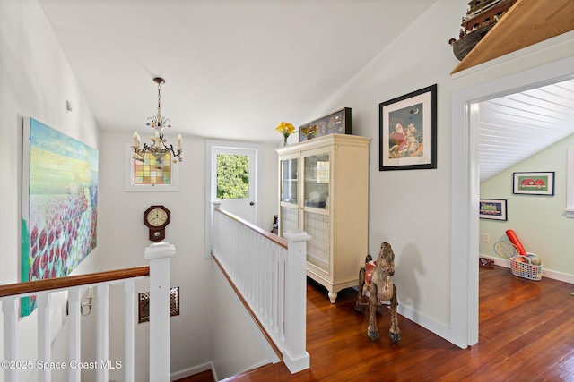 1248 Highland Ave, Melbourne, FL 32935 - hallway featuring an upstairs landing, a chandelier, dark wood-style flooring, vaulted ceiling, and baseboards