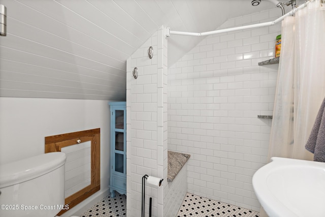 1248 Highland Ave, Melbourne, FL 32935 - bathroom with vaulted ceiling, a tile shower, toilet, and tile patterned floors