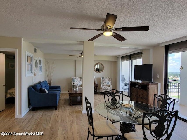 2100 N Atlantic Ave Unit 1207, Cocoa Beach, FL 32931 - dining room featuring a textured ceiling, a ceiling fan, light wood-style flooring, and baseboards
