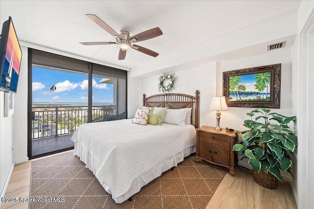 2100 N Atlantic Ave Unit 1207, Cocoa Beach, FL 32931 - bedroom featuring expansive windows, access to exterior, wood finished floors, and ceiling fan