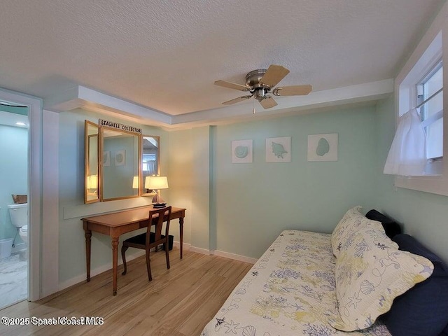 2100 N Atlantic Ave Unit 1207, Cocoa Beach, FL 32931 - bedroom with wood finished floors, a textured ceiling, baseboards, and ensuite bath