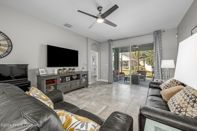 7673 Loren Cove Dr, Melbourne, FL 32940 - living room with a ceiling fan, arched walkways, baseboards, and tile patterned flooring