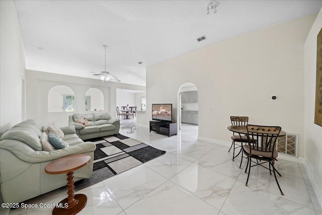 2125 Spring Creek Cir, Palm Bay, FL 32905 - living area with light marble finish floors, arched walkways, baseboards, and ceiling fan
