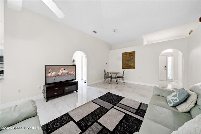 2125 Spring Creek Cir, Palm Bay, FL 32905 - living room featuring arched walkways, light marble finish floors, and baseboards