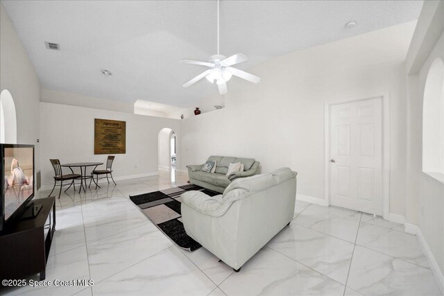 2125 Spring Creek Cir, Palm Bay, FL 32905 - living area with arched walkways, light marble finish floors, ceiling fan, lofted ceiling, and baseboards