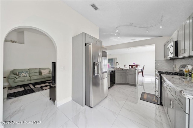 2125 Spring Creek Cir, Palm Bay, FL 32905 - kitchen with appliances with stainless steel finishes, gray cabinetry, light stone countertops, and a sink