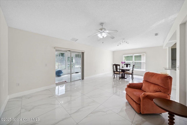 2125 Spring Creek Cir, Palm Bay, FL 32905 - sitting room featuring light marble finish floors, ceiling fan, healthy amount of natural light, and a textured ceiling