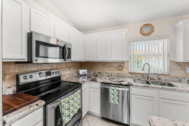 775 Triple Crown Ln, Melbourne, FL 32904 - kitchen featuring appliances with stainless steel finishes, a sink, white cabinetry, lofted ceiling, and tasteful backsplash