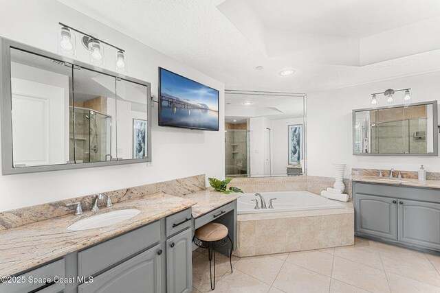 505 S Miramar Ave Unit 2403, Indialantic, FL 32903 - bathroom featuring a shower stall, two vanities, tile patterned floors, a bath, and recessed lighting