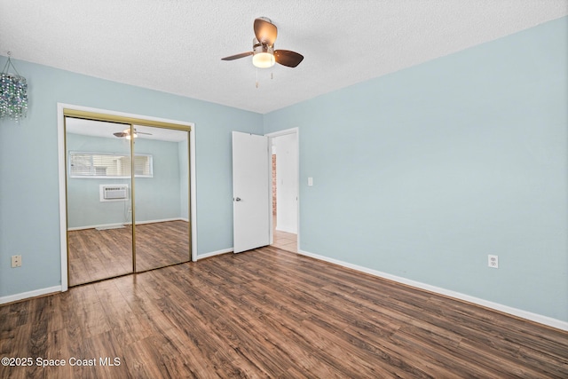 3820 Ocean Beach Blvd Unit 1, Cocoa Beach, FL 32931 - unfurnished bedroom with wood finished floors, baseboards, a closet, a wall mounted air conditioner, and a ceiling fan