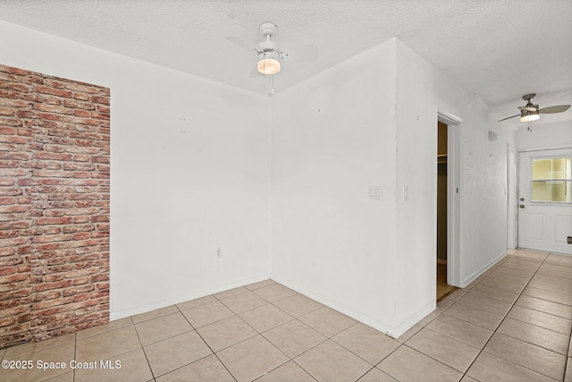 3820 Ocean Beach Blvd Unit 1, Cocoa Beach, FL 32931 - spare room with a ceiling fan, light tile patterned floors, a textured ceiling, and baseboards