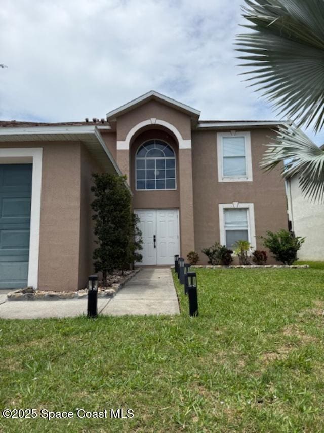 5256 Mansford Pl, Melbourne, FL 32940 - view of front facade with stucco siding and a front yard