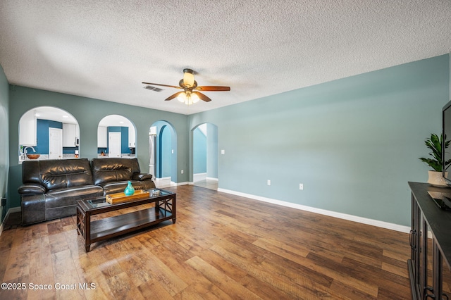 5256 Mansford Pl, Melbourne, FL 32940 - living area featuring arched walkways, a ceiling fan, hardwood / wood-style flooring, baseboards, and a textured ceiling