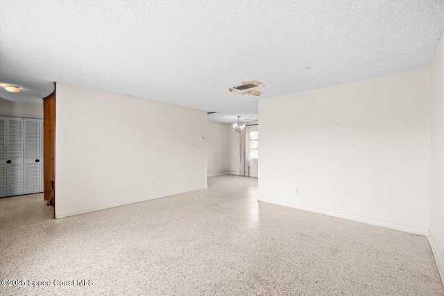 1155 Montego Bay Dr N, Merritt Island, FL 32953 - unfurnished room featuring speckled floor, a chandelier, and a textured ceiling