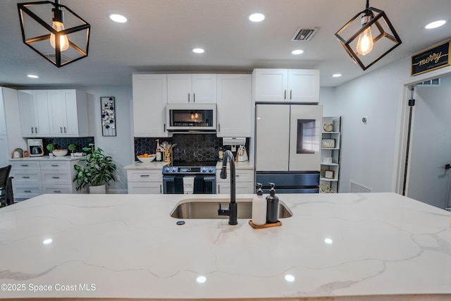 629 Tupelo Dr, Melbourne, FL 32935 - kitchen with white appliances, hanging light fixtures, decorative backsplash, recessed lighting, and white cabinets
