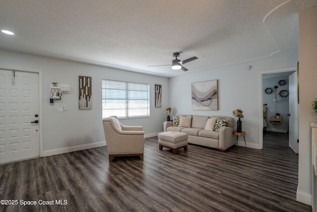 629 Tupelo Dr, Melbourne, FL 32935 - living room with ceiling fan, dark wood-style floors, baseboards, and a textured ceiling