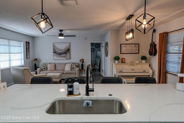 629 Tupelo Dr, Melbourne, FL 32935 - kitchen with a sink, pendant lighting, light stone countertops, ceiling fan, and open floor plan