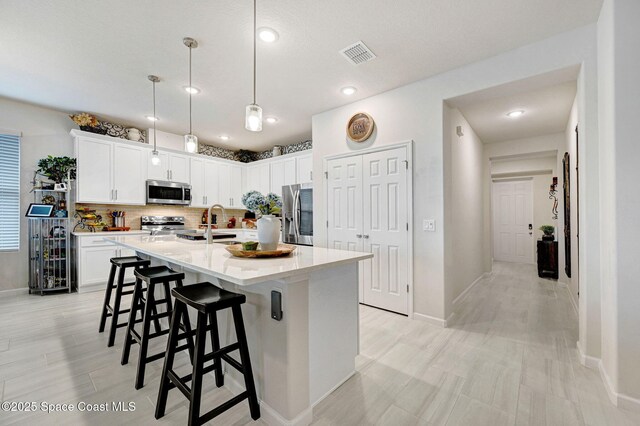 2365 Roygaris St NW, Palm Bay, FL 32907 - kitchen featuring stainless steel appliances, a kitchen breakfast bar, backsplash, a sink, and light countertops