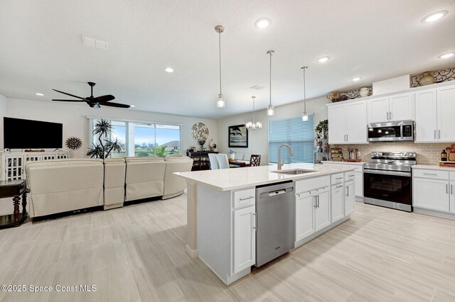 2365 Roygaris St NW, Palm Bay, FL 32907 - kitchen featuring appliances with stainless steel finishes, open floor plan, a sink, a ceiling fan, and light countertops