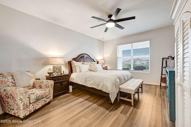 2365 Roygaris St NW, Palm Bay, FL 32907 - bedroom featuring light wood-type flooring, a ceiling fan, baseboards, and a brick fireplace