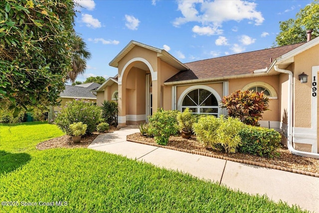 1090 Spring Oak Dr, Melbourne, FL 32901 - view of front facade featuring a front lawn, stucco siding, and roof with shingles