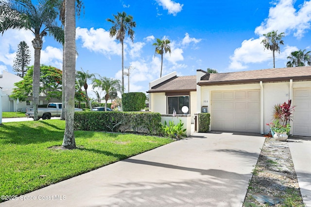 525 Summerset Ct, Indian Harbour Beach, FL 32937 - view of front facade with stucco siding, an attached garage, driveway, and a front lawn