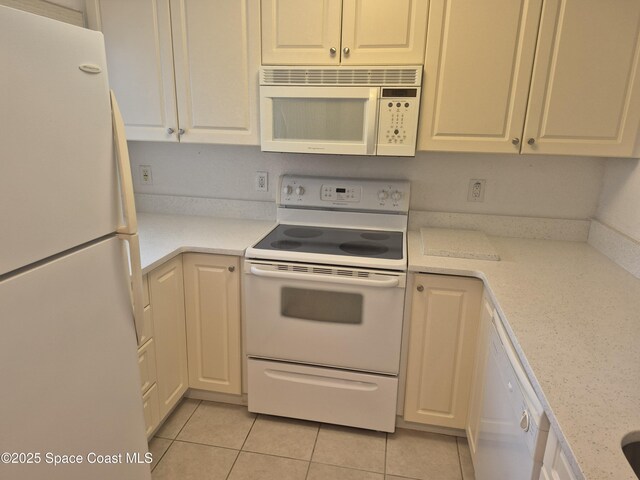 640 Seaport Blvd Unit 224, Cape Canaveral, FL 32920 - kitchen with white appliances, light tile patterned floors, and white cabinets