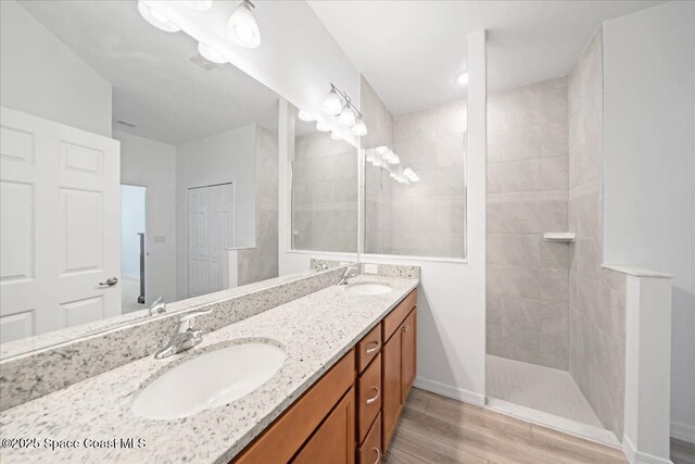 8342 Laguna Cir, Micco, FL 32976 - full bathroom featuring double vanity, a walk in shower, wood finished floors, and baseboards